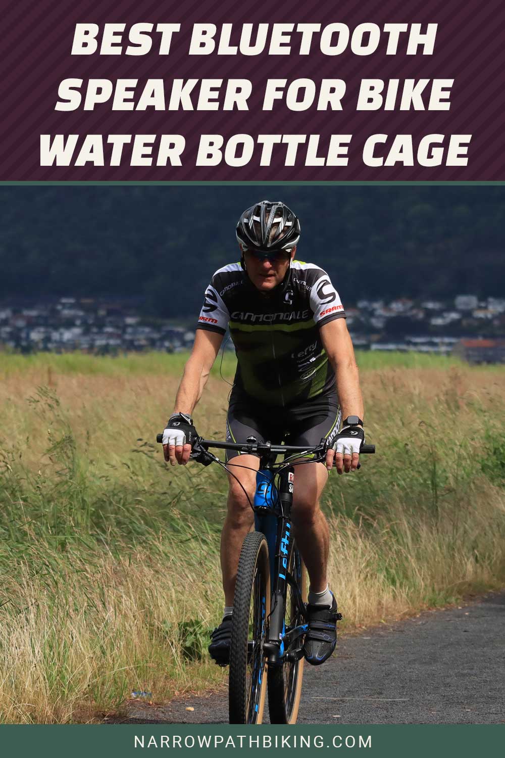 Person riding a bike on a road near tall grass - Best Bluetooth Speaker for Bike Water Bottle Cage.